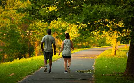 A couple walking through a park on a path in Greenville, TX